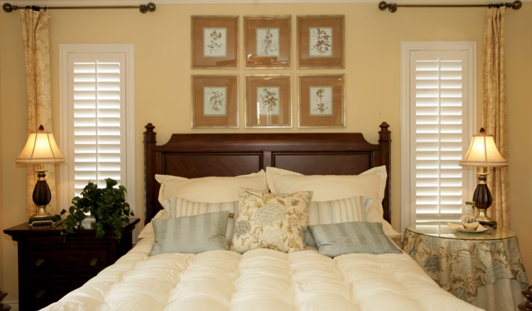 Beige bedroom with white plantation shutters covering windows in Dallas 